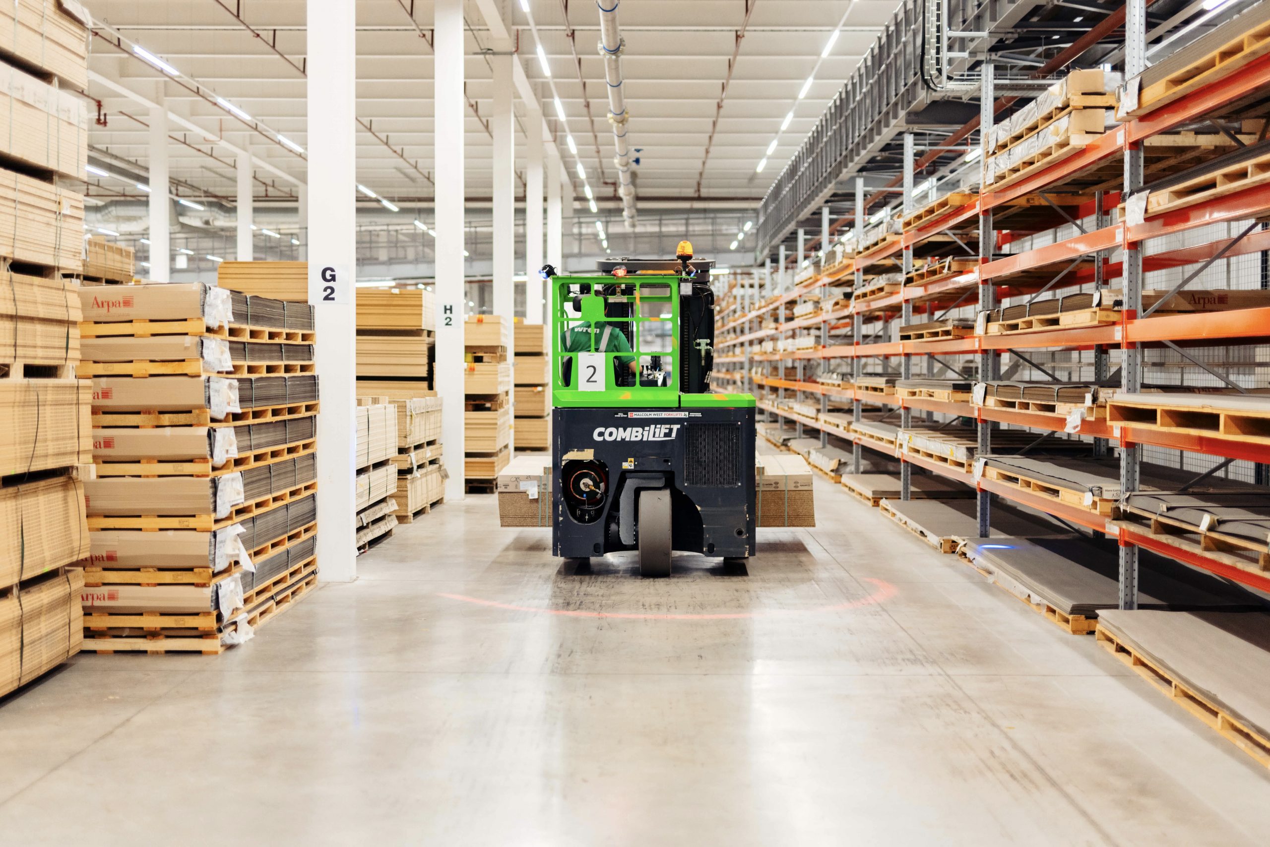 Inside Parrott Street factory, a team member driving a forklift truck through the aisles.