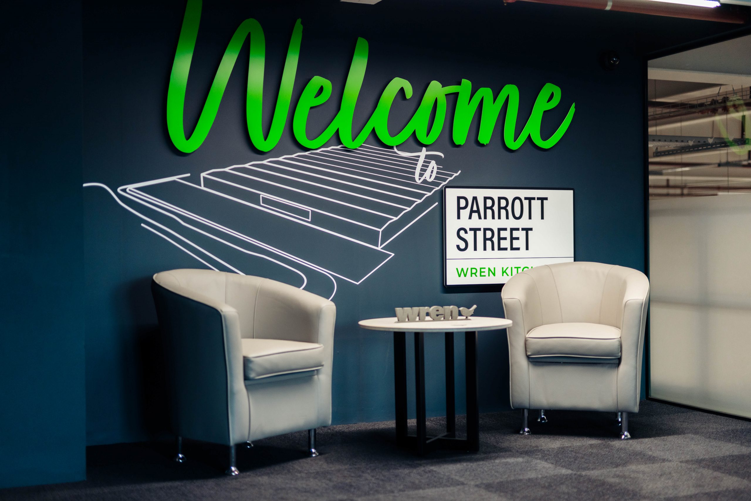 Welcome to Parrott Street sign with two chairs